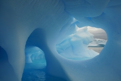 A blue iceberg floats adrift in a bay of the Antarctic Peninsula